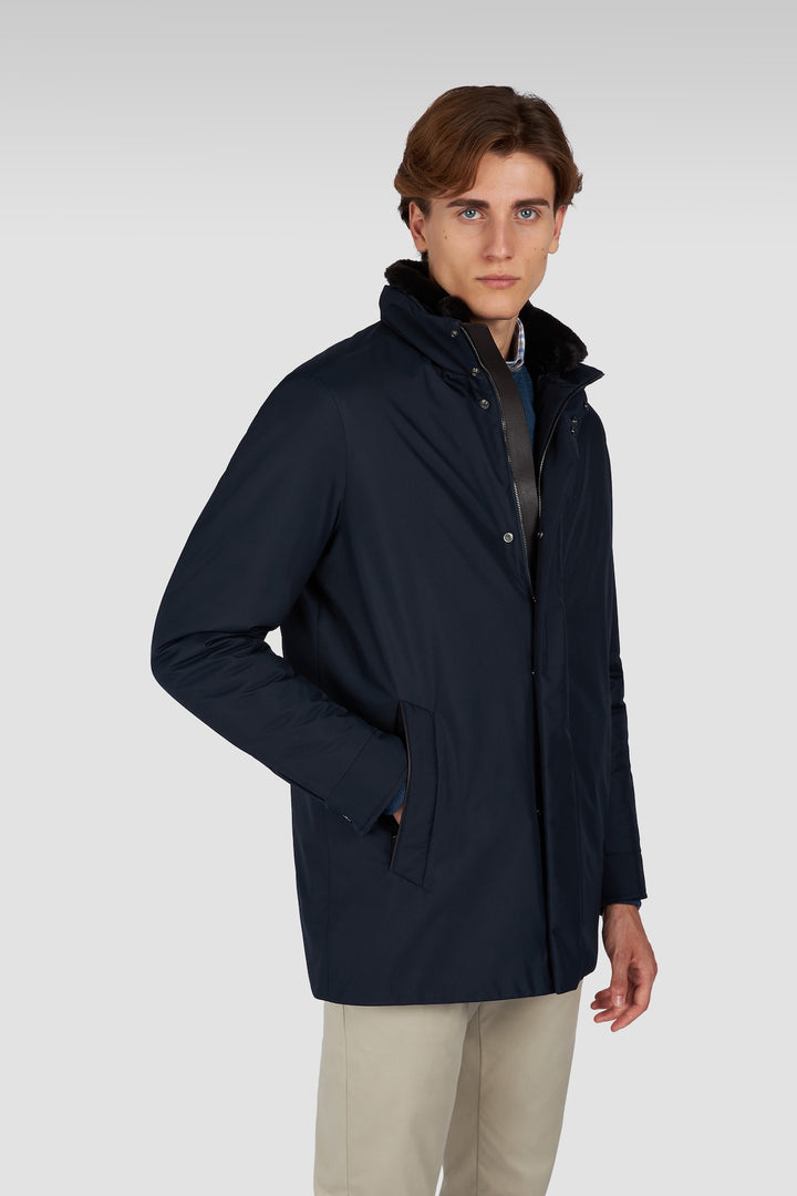 Manteau à col montant matelassé en tissu technique, offrant élégance et confort, porté par un mannequin en tenue urbaine.