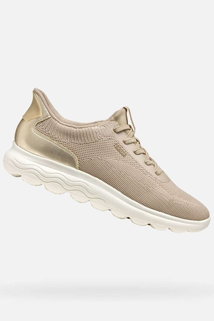 Basket en maille extensible beige pour femme avec technologie Fast In et semelle amortissante flottant sur fond blanc.