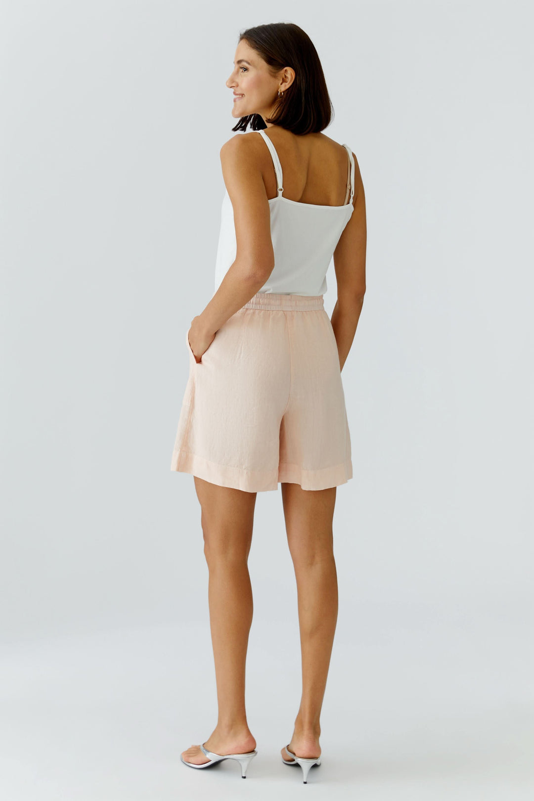 Femme portant un Bermuda coupe moderne beige, confortable et stylé pour un look décontracté et chic en été.