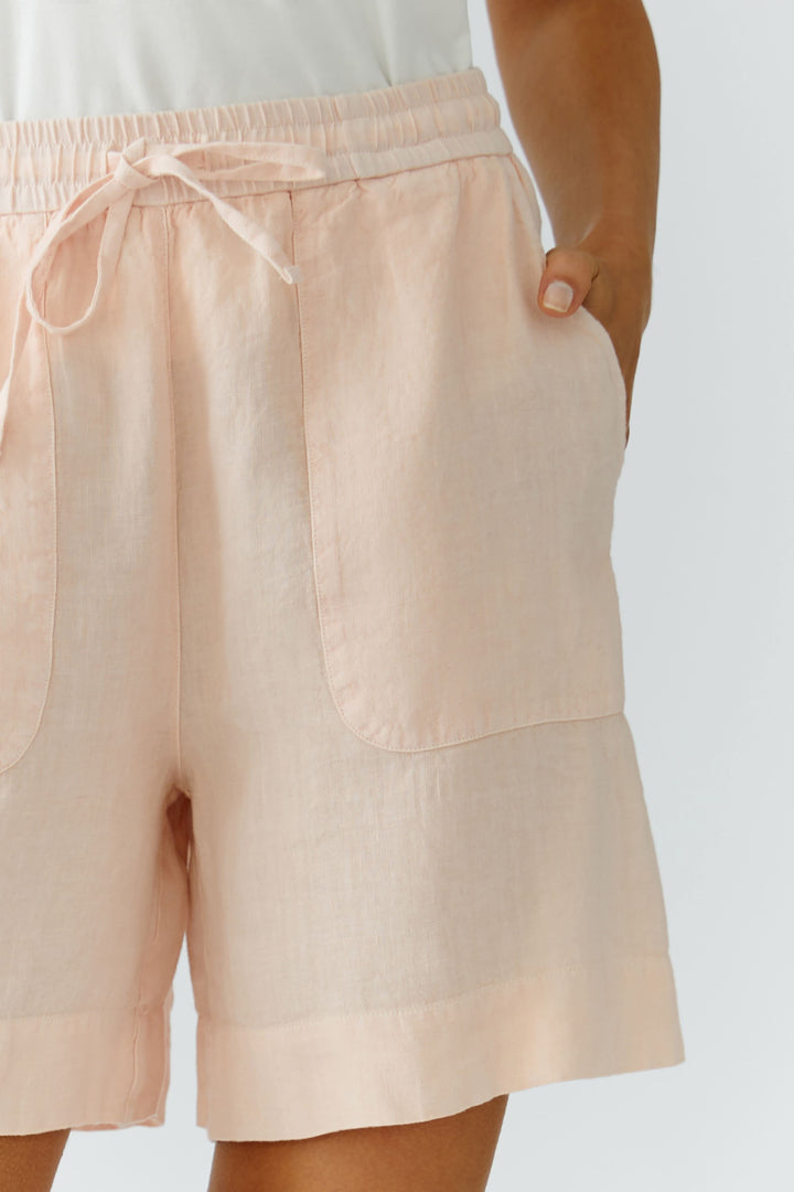 Bermuda coupe moderne en lin rose avec taille élastique et poches, idéal pour un style contemporain et décontracté.