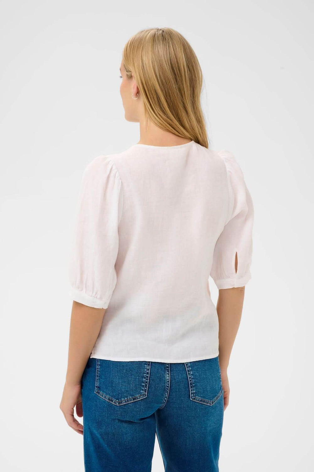 Femme portant Blouse Azra, chemisier léger à manches bouffantes, coupe droite, encolure ronde, style intemporel.