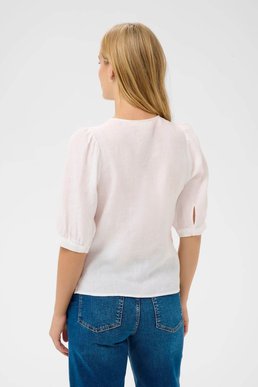Femme portant Blouse Azra, chemisier léger à manches bouffantes, coupe droite, encolure ronde, style intemporel.