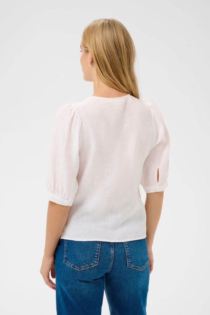 Femme portant Blouse Azra, chemisier léger à manches bouffantes, coupe droite, encolure ronde, style intemporel.