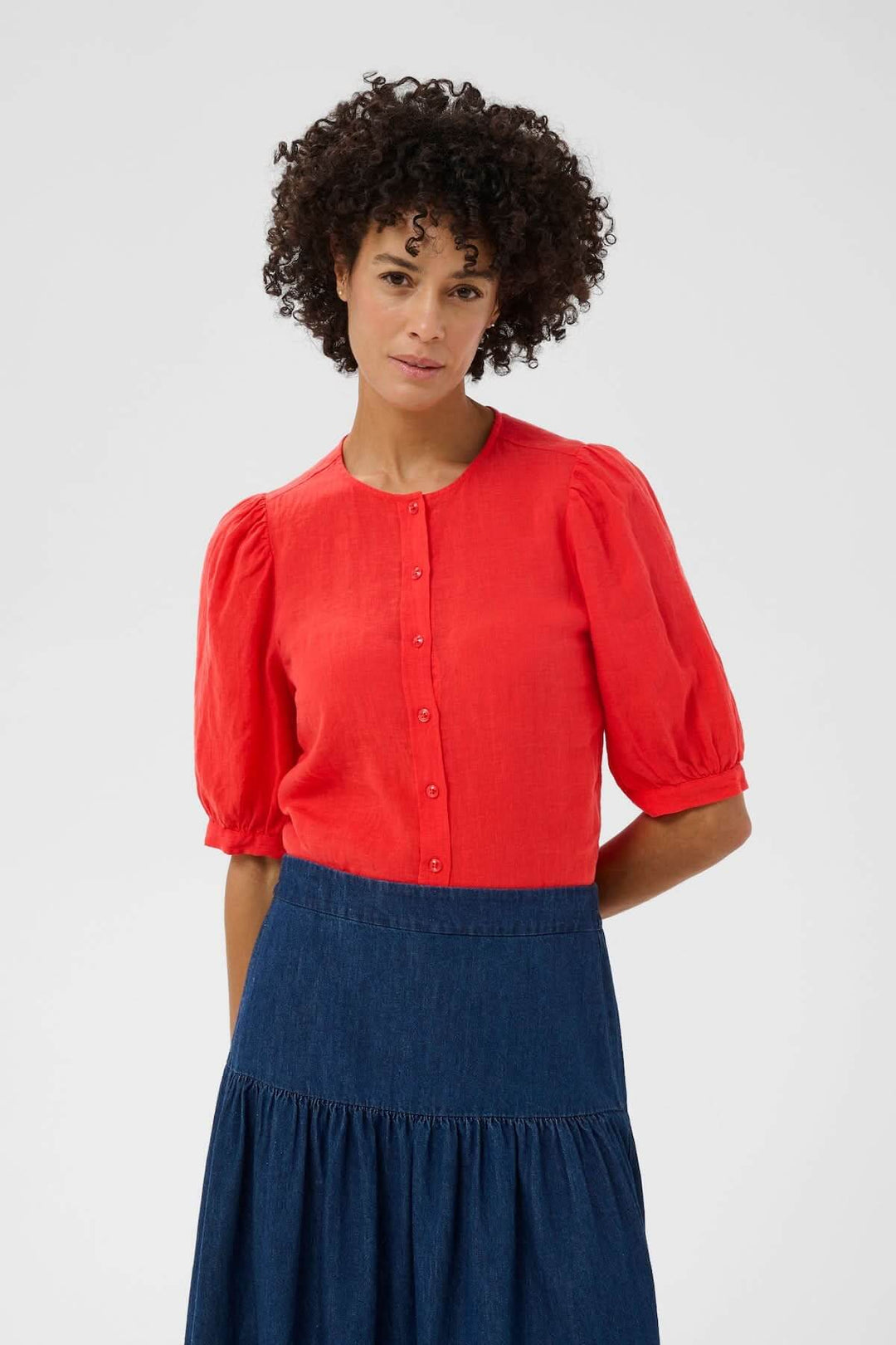 Femme portant la Blouse Azra avec manches bouffantes et coupe droite, idéale pour un style décontracté ou soigné.