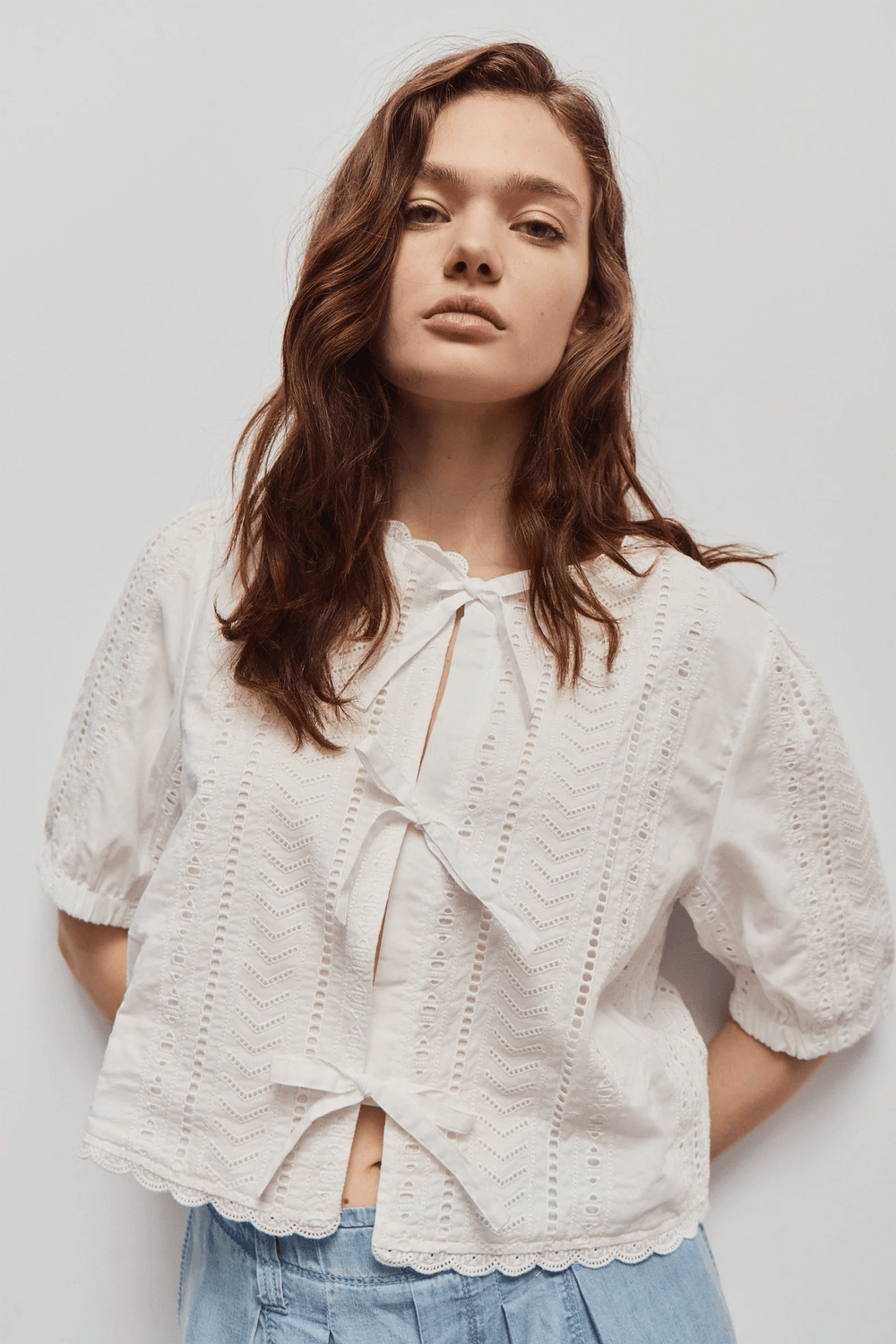 Blouse Giana brodée à nouer avec broderies ajourées, manches courtes et coupe moderne pour l'été.