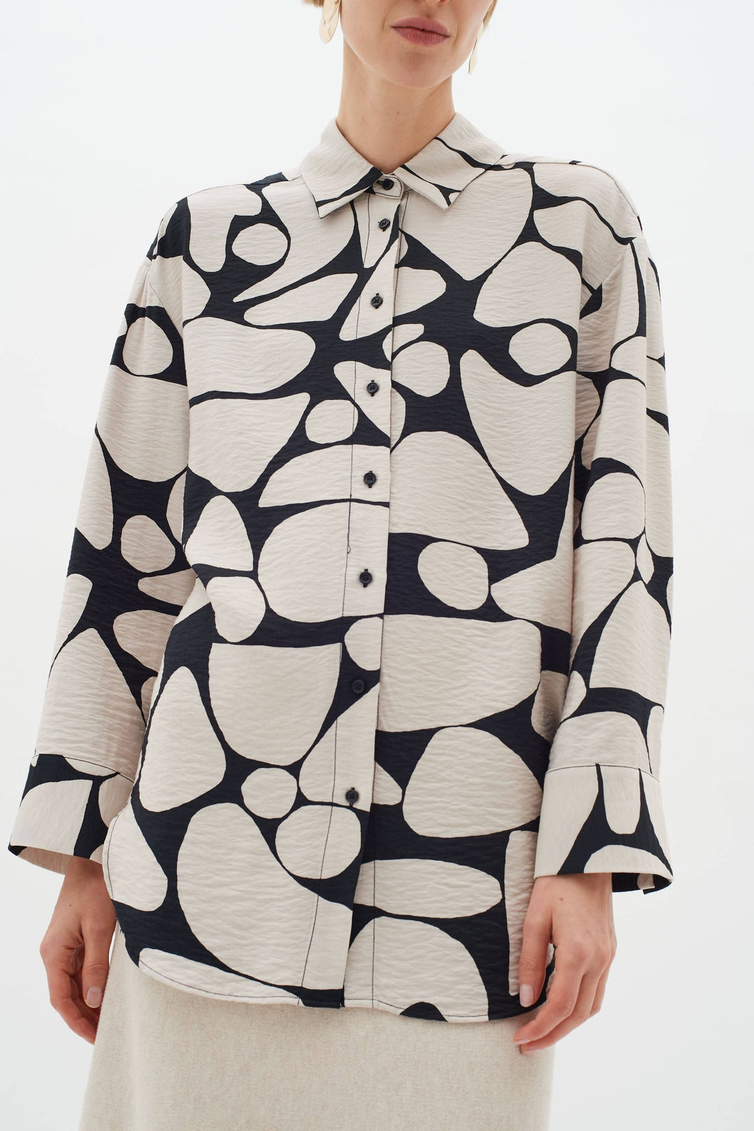 Blouse Metta classique avec col, manches longues et imprimé abstrait en noir et crème.