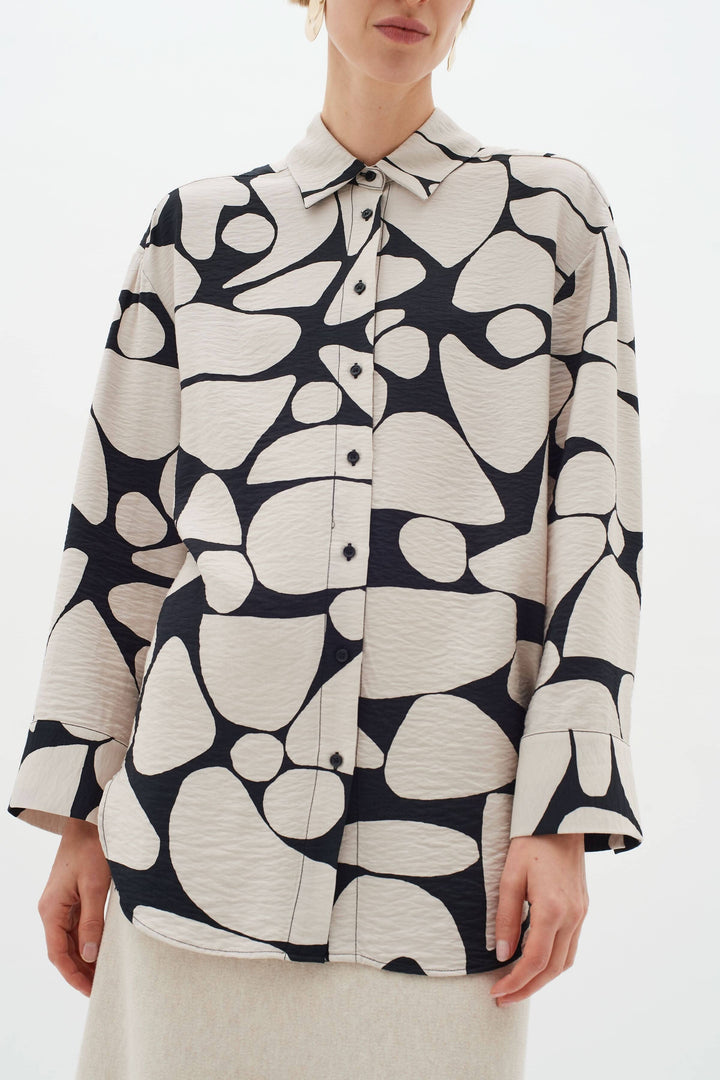 Blouse Metta classique avec col, manches longues et imprimé abstrait en noir et crème.