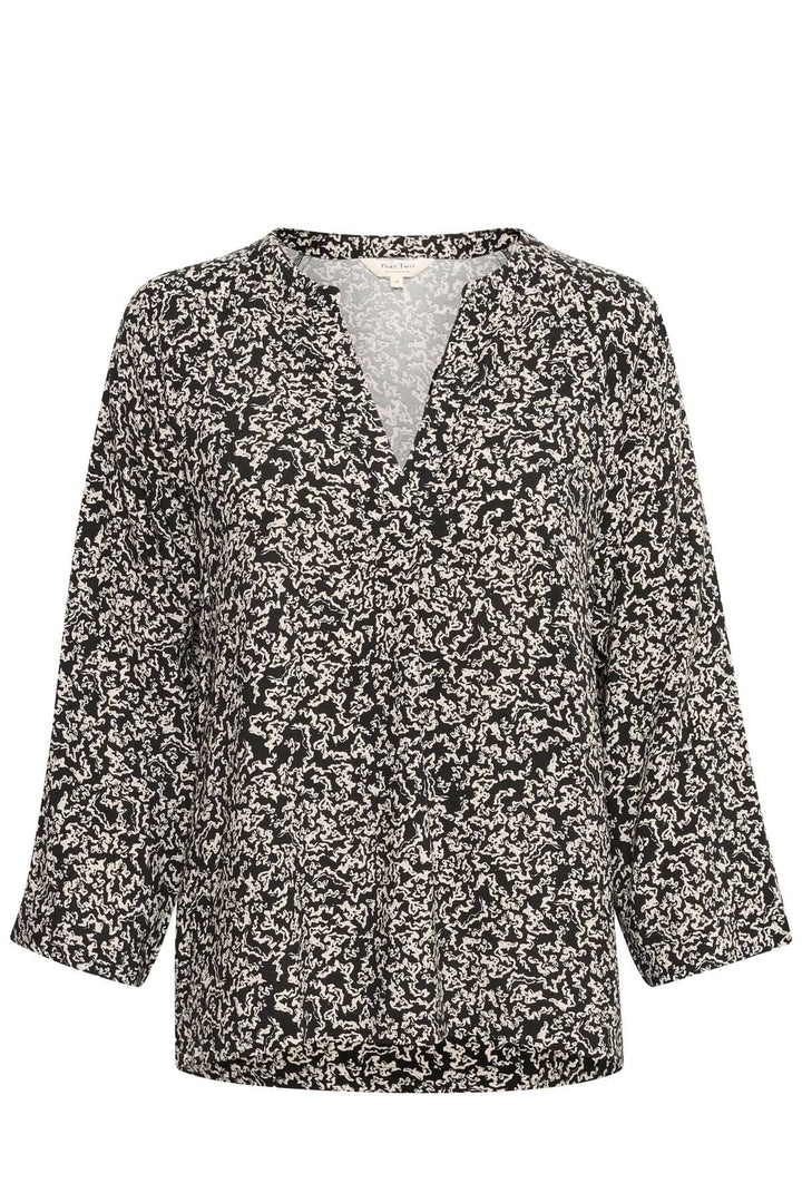Chemisier fluide noir et blanc à motifs, encolure en V et manches 3/4, idéal pour un look chic et minimaliste.