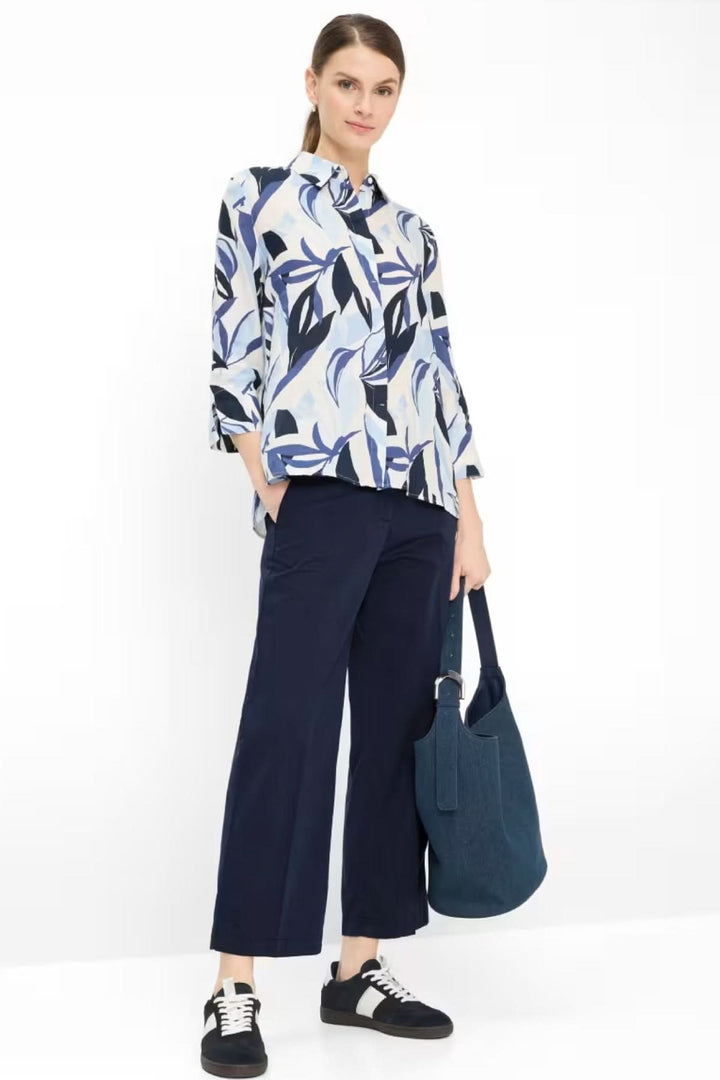 Femme portant la Blouse VICKI en lin avec imprimé graphique, col classique et manches trois-quarts, tenue élégante et fluide.