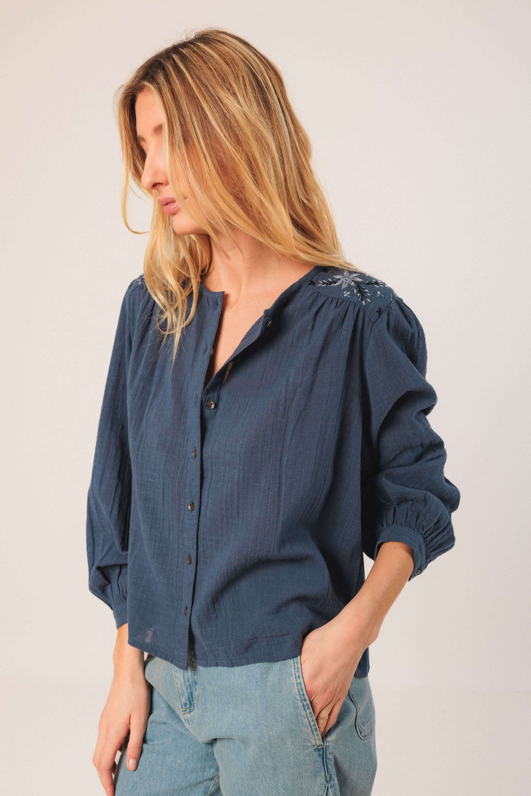Blouse brodée fluide bleu avec encolure ronde et manches bouffantes, idéale pour un look décontracté.