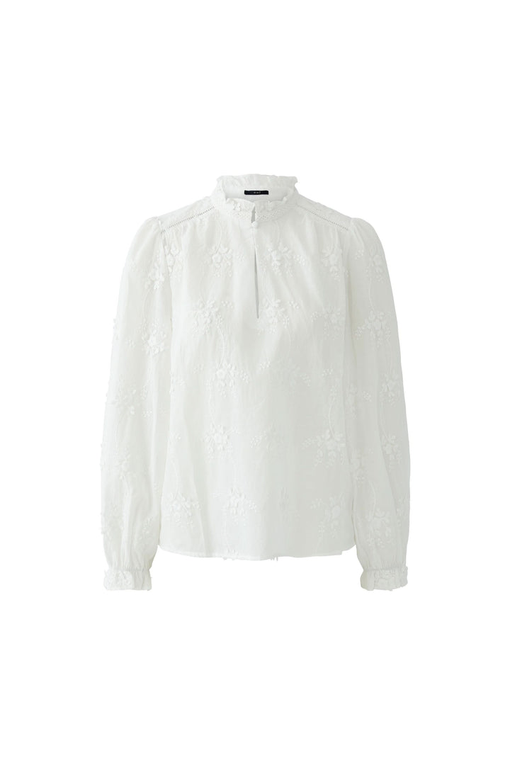 Blouse à broderies florales avec col montant, manches longues et broderie délicate pour un style élégant et féminin.