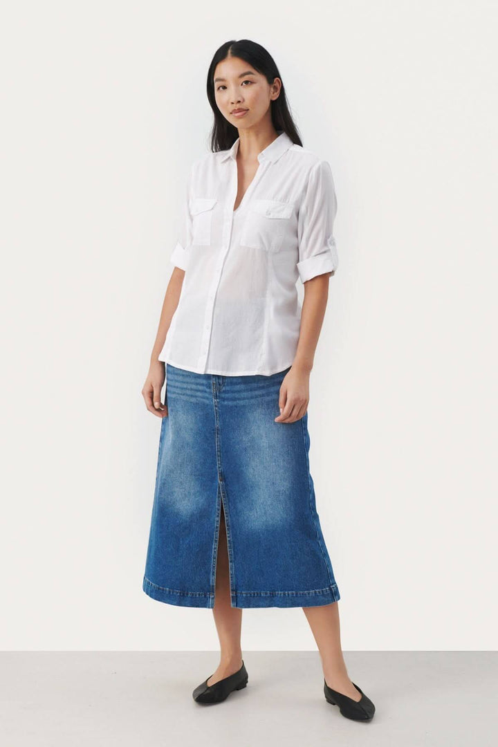 Modèle portant une blouse de coton Cortnia avec une jupe en denim, look décontracté et chic.