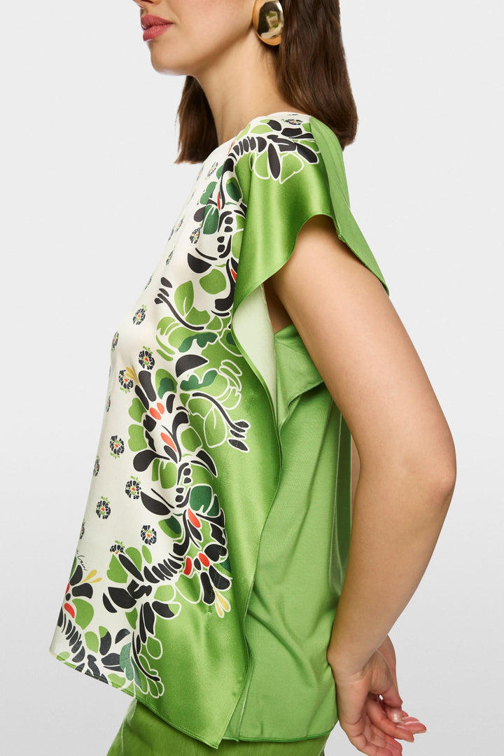 Blouse fluide imprimée verte avec manches courtes et design artistique, vue de profil sur mannequin