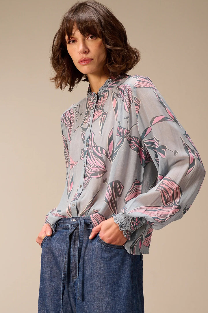 Blouse fluide à manches longues élégante avec imprimé floral et col montant, portée par mannequin, idéale pour la mi-saison