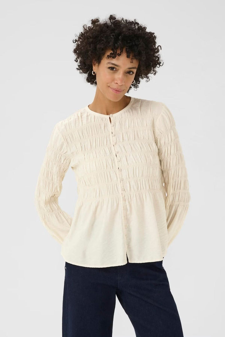 Blouse à fronces en tissu texturé avec encolure ronde et patte boutonnée, idéale pour un style casual chic ou raffiné.