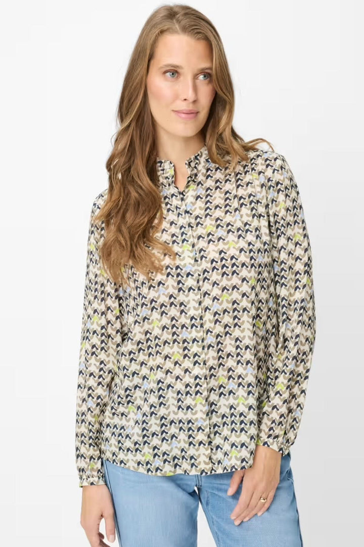 Blouse imprimée à motif féminin et fluide, idéale pour une tenue soignée ou décontractée, portée par une femme.