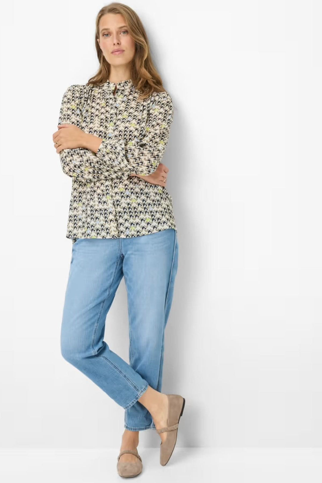 Femme portant une blouse imprimée féminine et fluide, idéale pour un look quotidien ou soigné, avec un style moderne et confortable.
