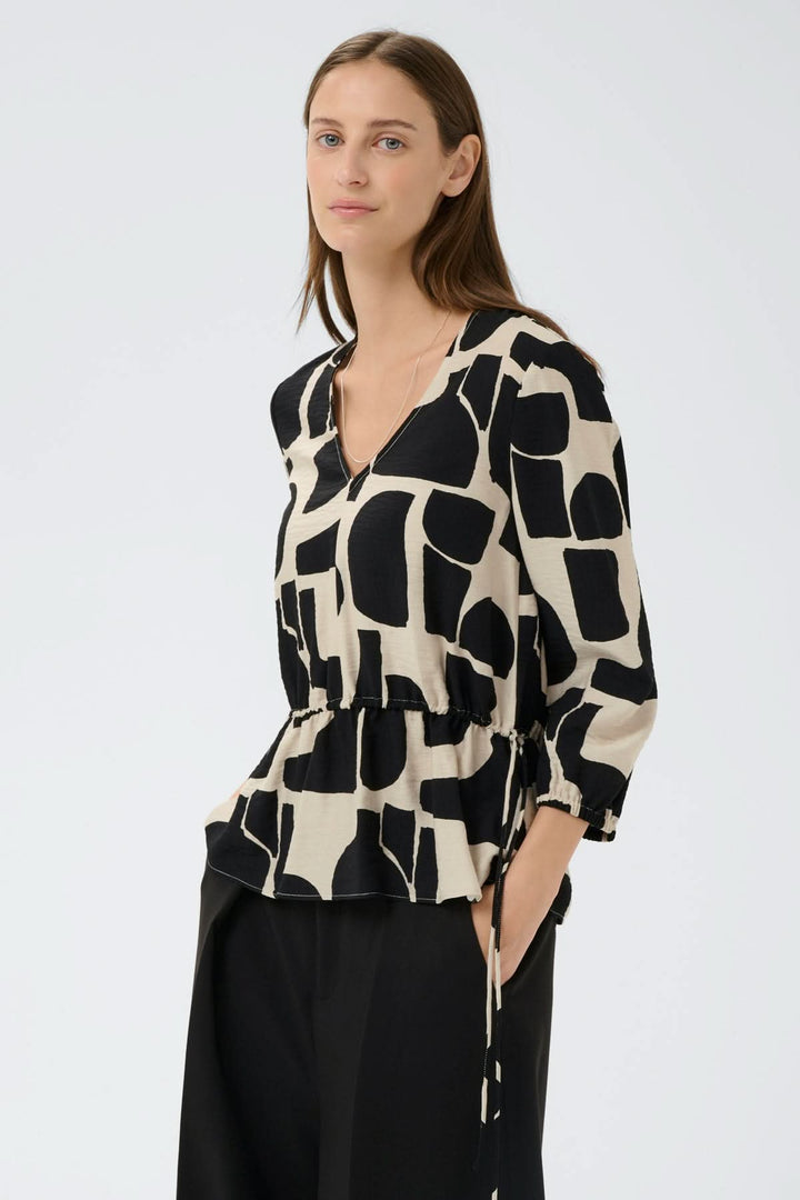 Blouse imprimée taille ajustable Lyn avec motif graphique, manches ¾ et encolure en V pour une silhouette féminine et contemporaine.