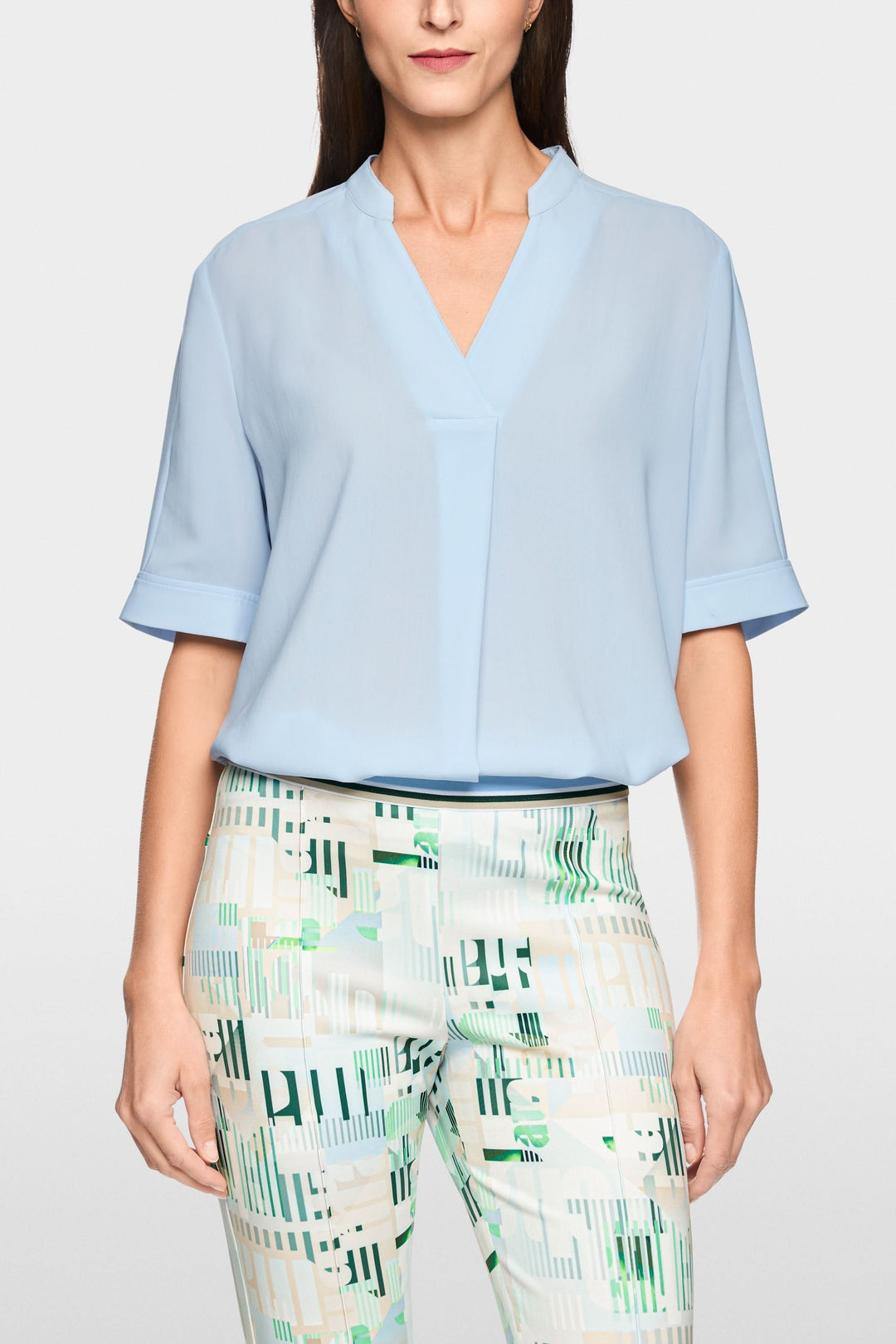 Blouse à manches courtes fluide avec encolure en V, design élégant et moderne, manches courtes à revers.