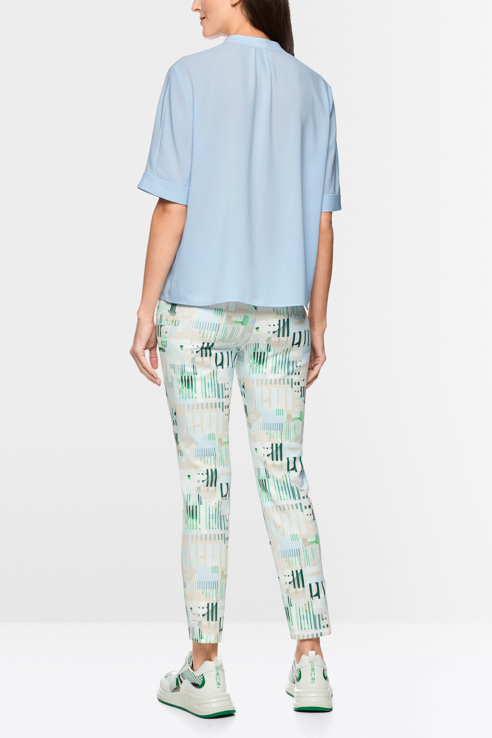 Blouse à manches courtes bleue avec coupe fluide et détails modernes, vue de dos pour un style minimaliste et élégant.