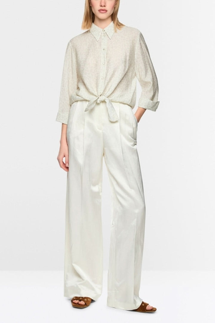 Blouse à nœuds en viscose avec manches trois-quarts et motif léopard discret, présentée sur un mannequin portant un pantalon blanc.