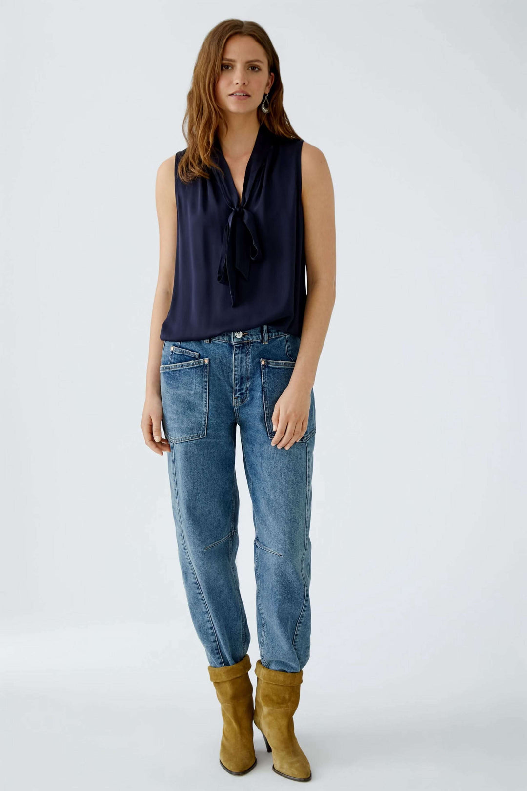 Femme portant une blouse évasée en satin avec ceinture élastiquée et volants, style décontracté et élégant.