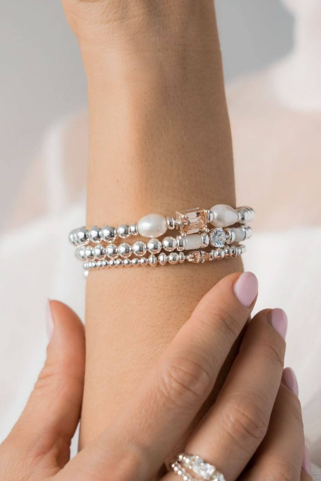 Bracelet en argent Be Iconic avec perles et breloques en zirconium, ajoutant élégance et lumière au poignet.