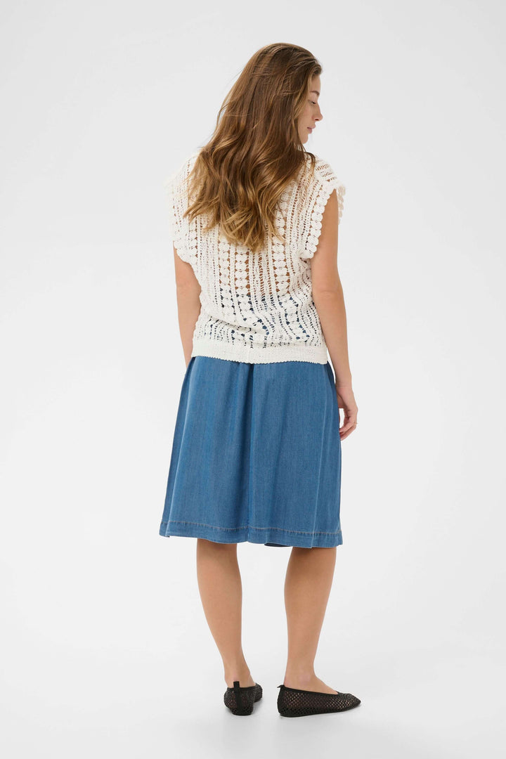 Femme portant une Camisole Tilda en maille ajourée blanche avec jupe en jean, vue arrière.