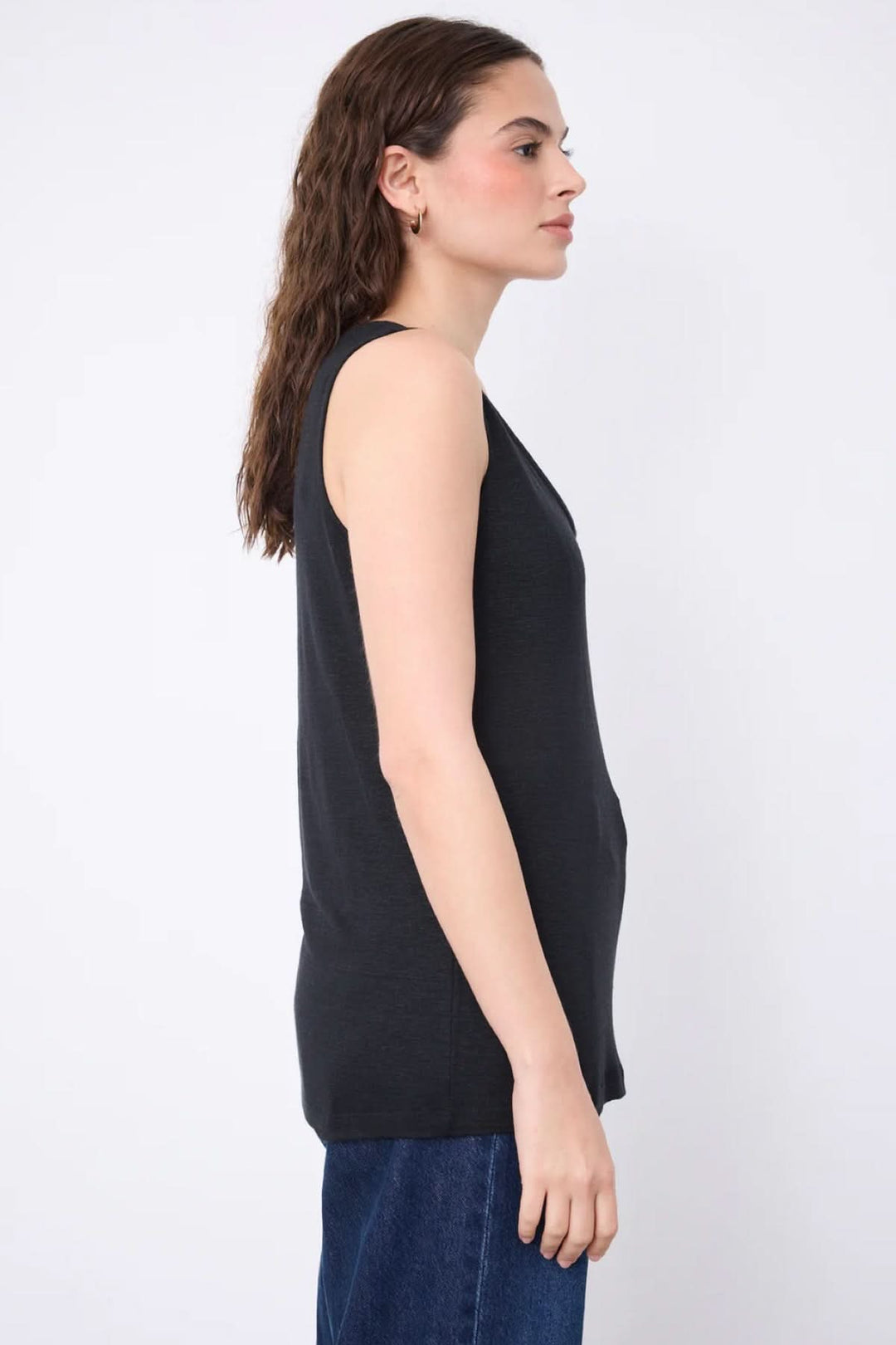 Vue latérale de la Camisole Yana en maille légère, sans manches, finition épurée, portée avec un jean.
