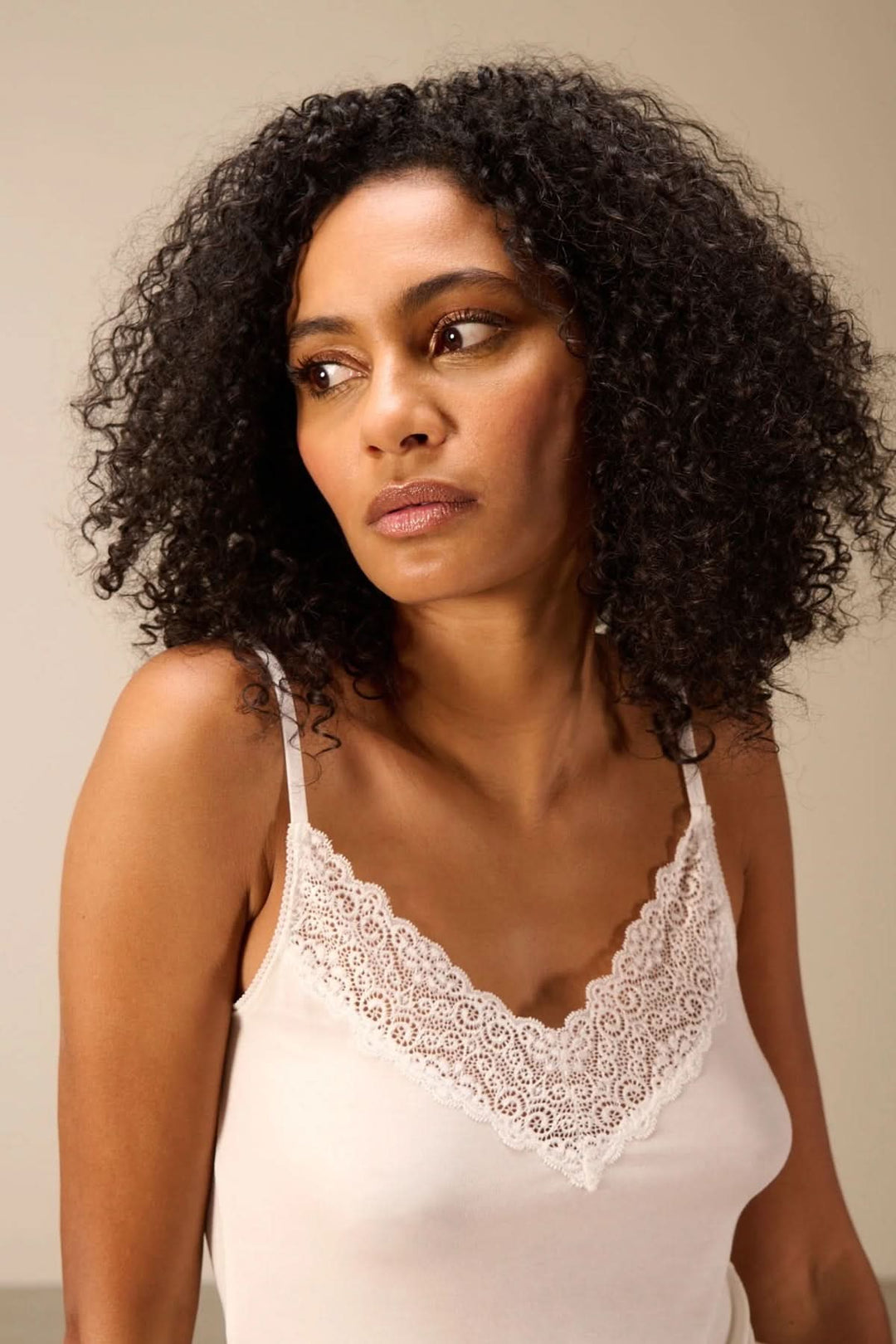 Femme portant une camisole à bretelles avec dentelle, soulignant l&