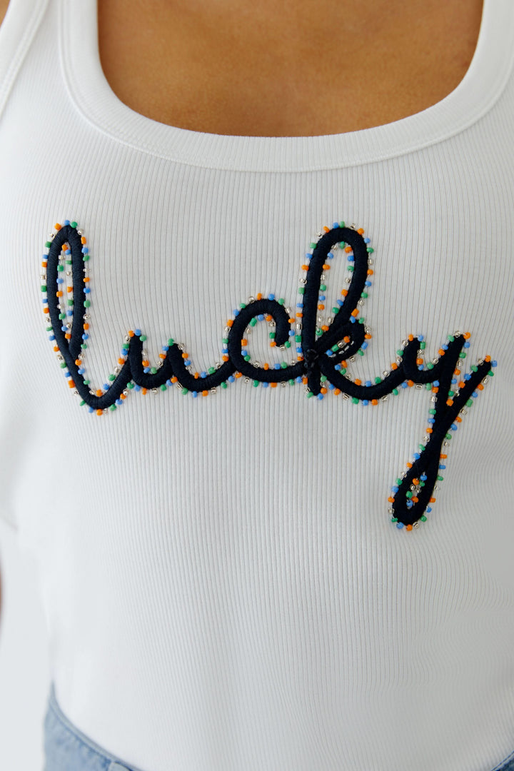 Camisole côtelée avec inscription brodée "lucky" sur fond blanc, design ajusté et confortable pour un look décontracté.
