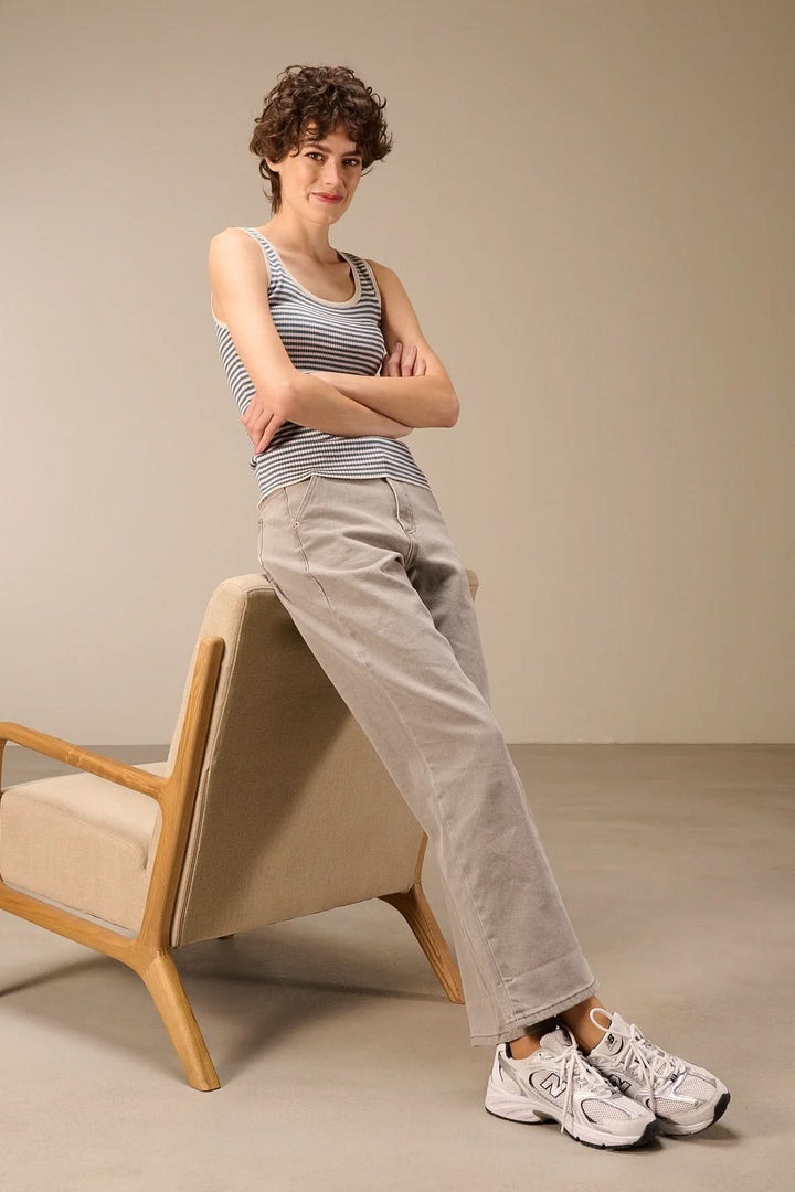 Femme portant une camisole côtelée rayée col rond, posant près d&