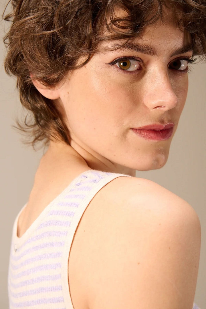 Femme portant une camisole côtelée rayée col rond avec bretelles larges, vue de dos. Top ajusté et moderne pour un look estival décontracté.