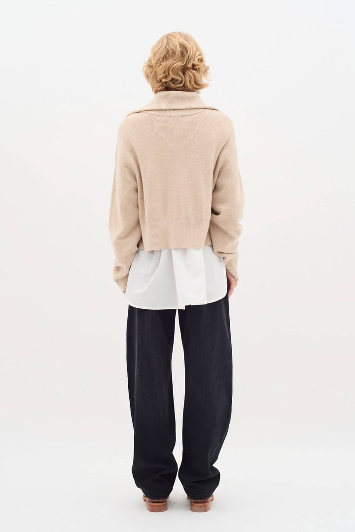 Cardigan Jogan beige à fermeture zippée, porté avec un t-shirt blanc et un pantalon noir, vue arrière.