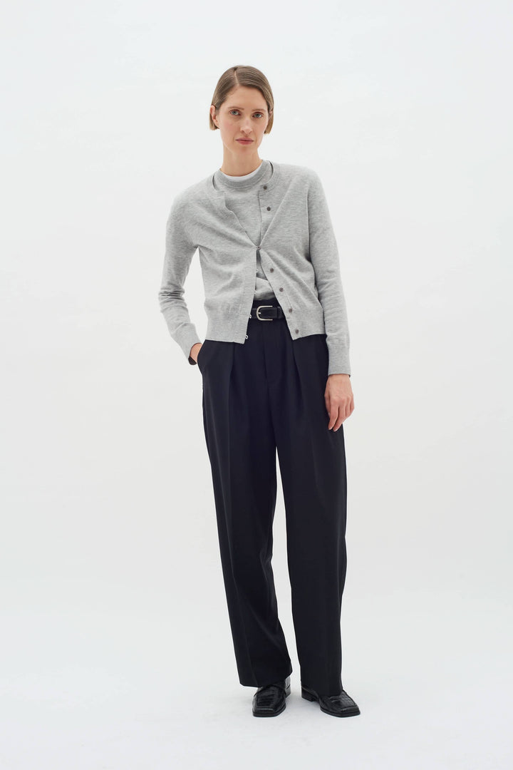 Modèle féminin portant le cardigan Kellsie gris chiné avec un pantalon noir élégant.