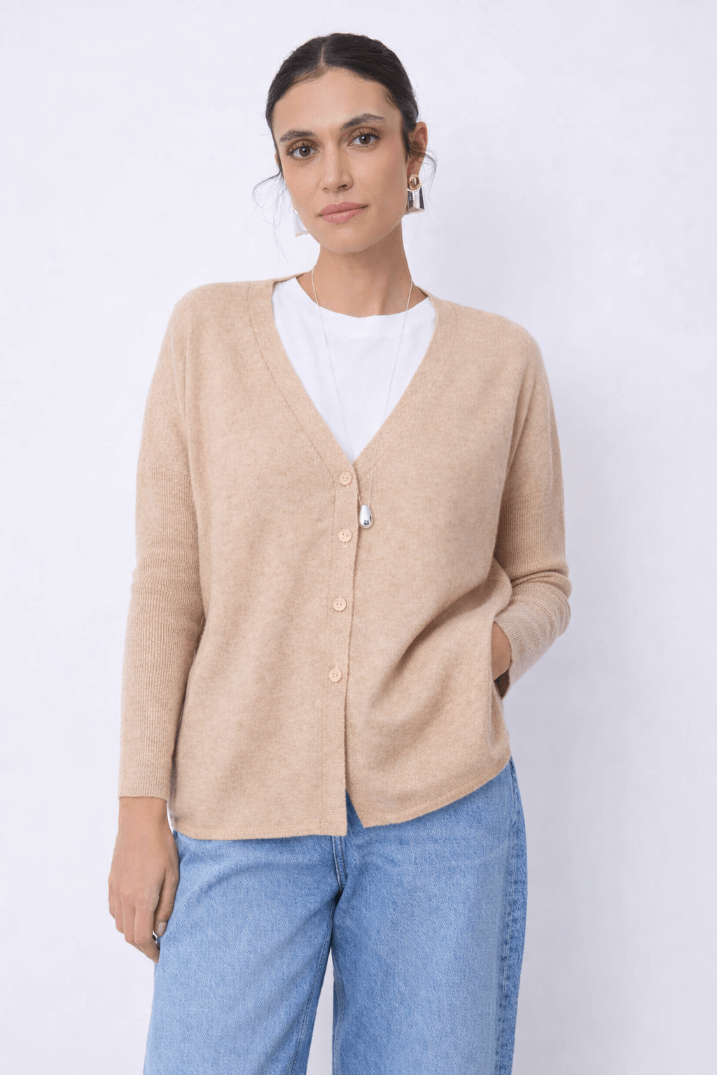 Cardigan en cachemire Alicia avec coupe droite et encolure en V, femme le portant avec un t-shirt blanc et un jean bleu clair.