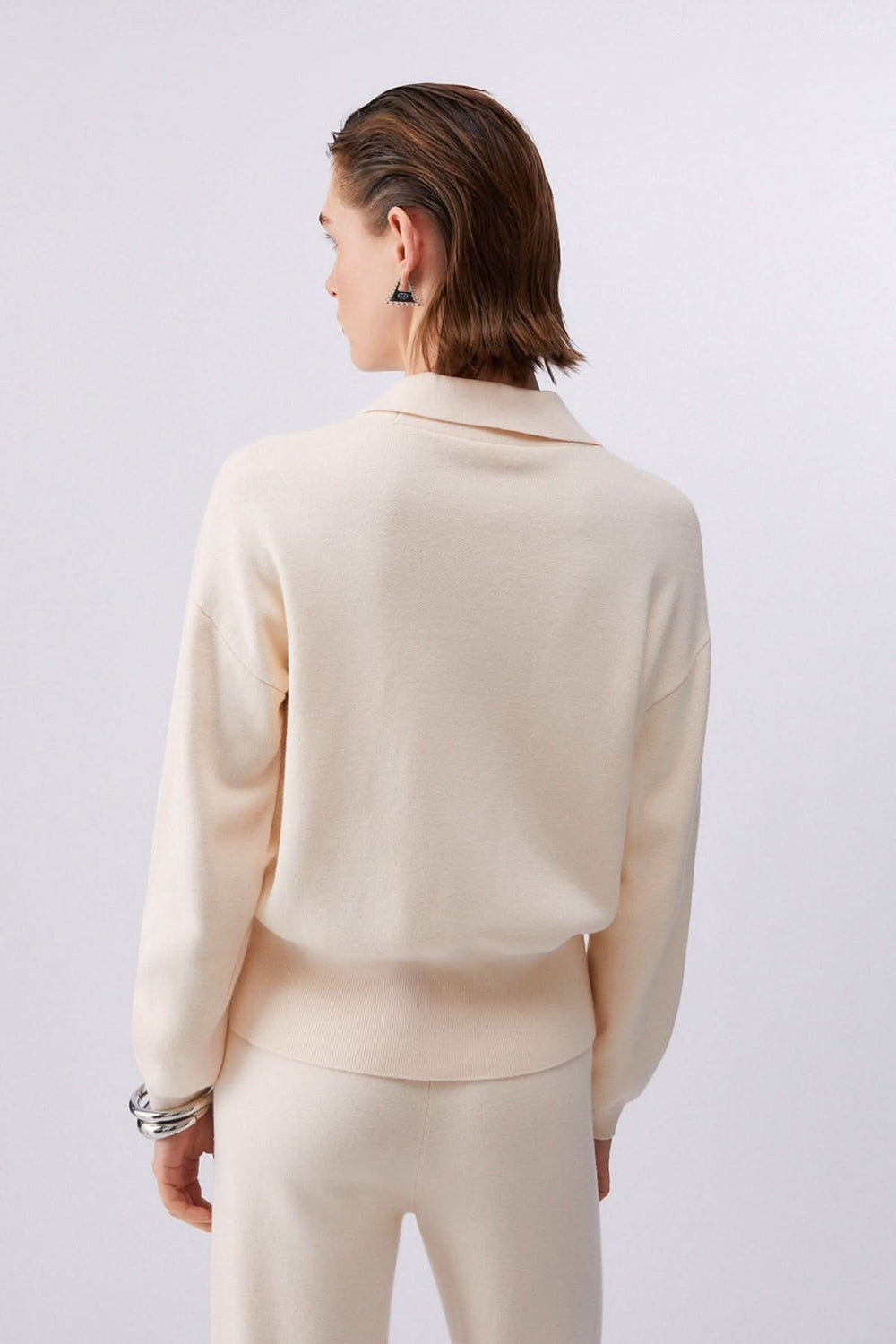 Vue arrière d'un cardigan en maille avec poches décoratives, col chemisier et fermeture boutonnée, portant élégance et confort.