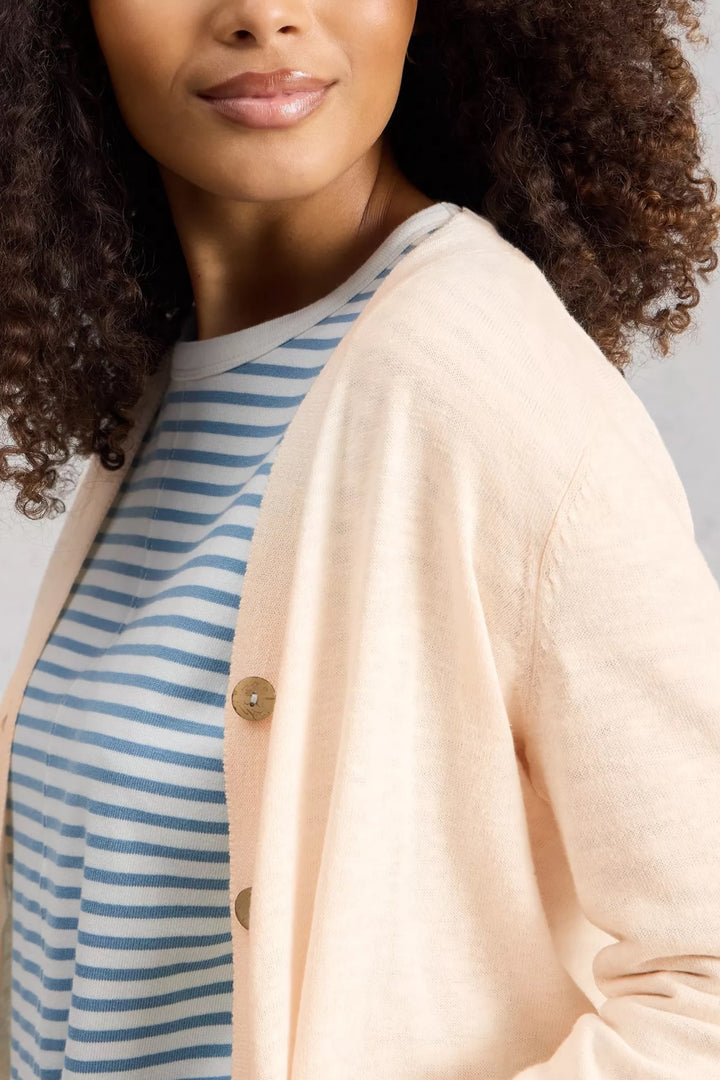Cardigan en mélange de lin Nova avec encolure en V porté sur un t-shirt rayé bleu et blanc, boutons visibles, manches longues.