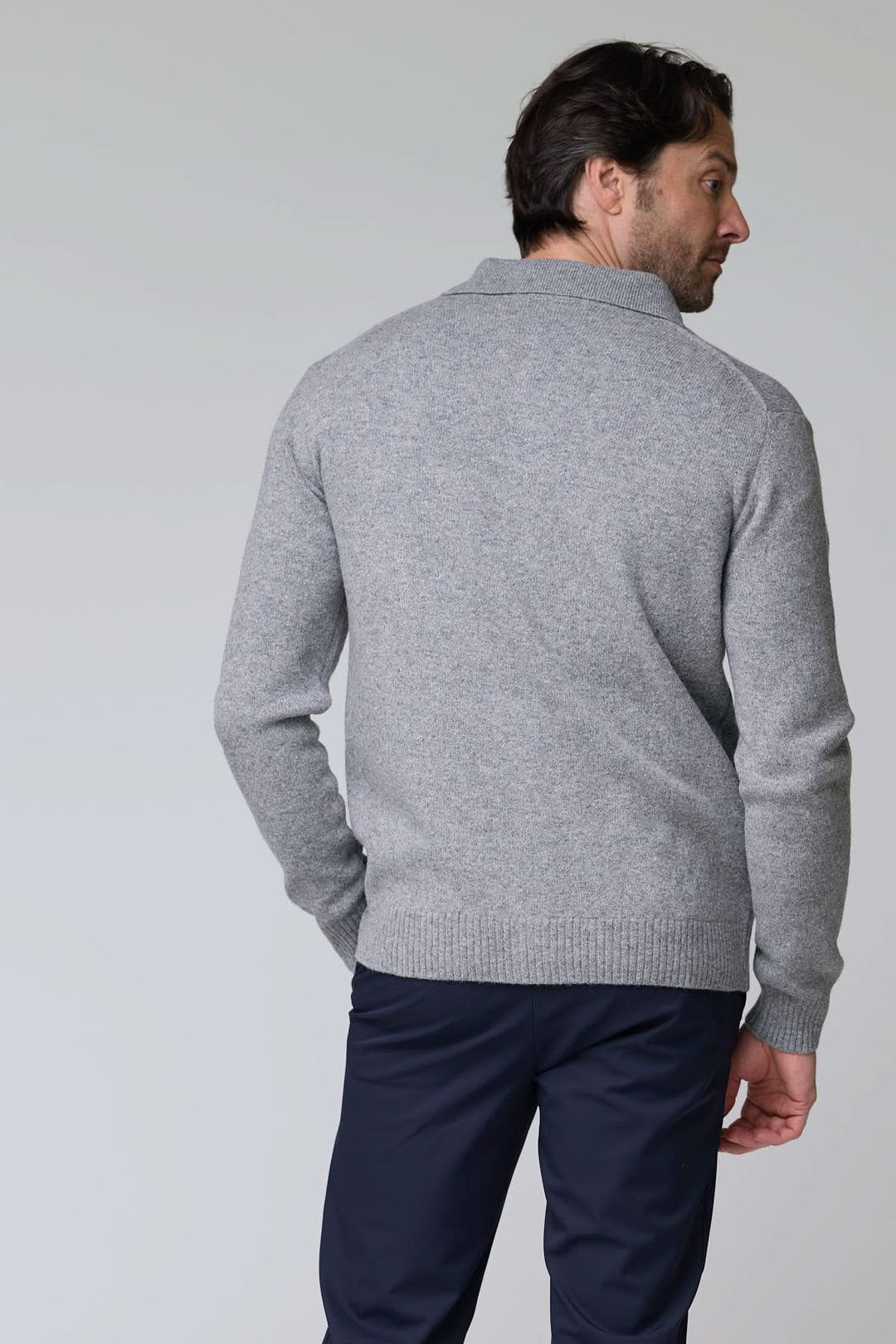 Homme portant un cardigan à poches plaquées en laine gris, style utilitaire chic, vue arrière.