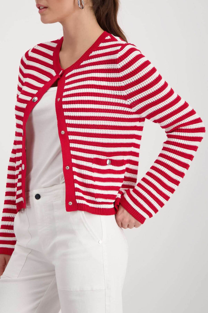Femme portant un cardigan rayé boutonné rouge et blanc, avec une coupe droite et encolure arrondie, style décontracté et soigné.