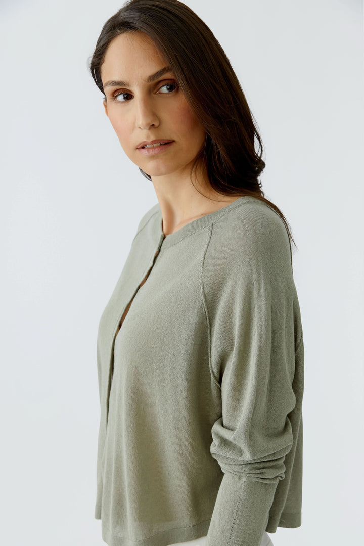 Femme portant un cardigan texturé boutonné avec encolure arrondie et texture délicate, idéal pour une tenue élégante et décontractée.