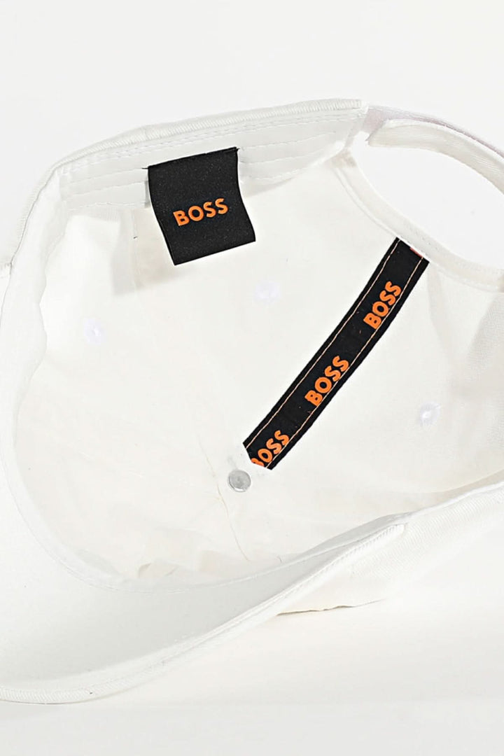 Détail intérieur de la casquette BOSS avec étiquette et bandeau noir et orange.