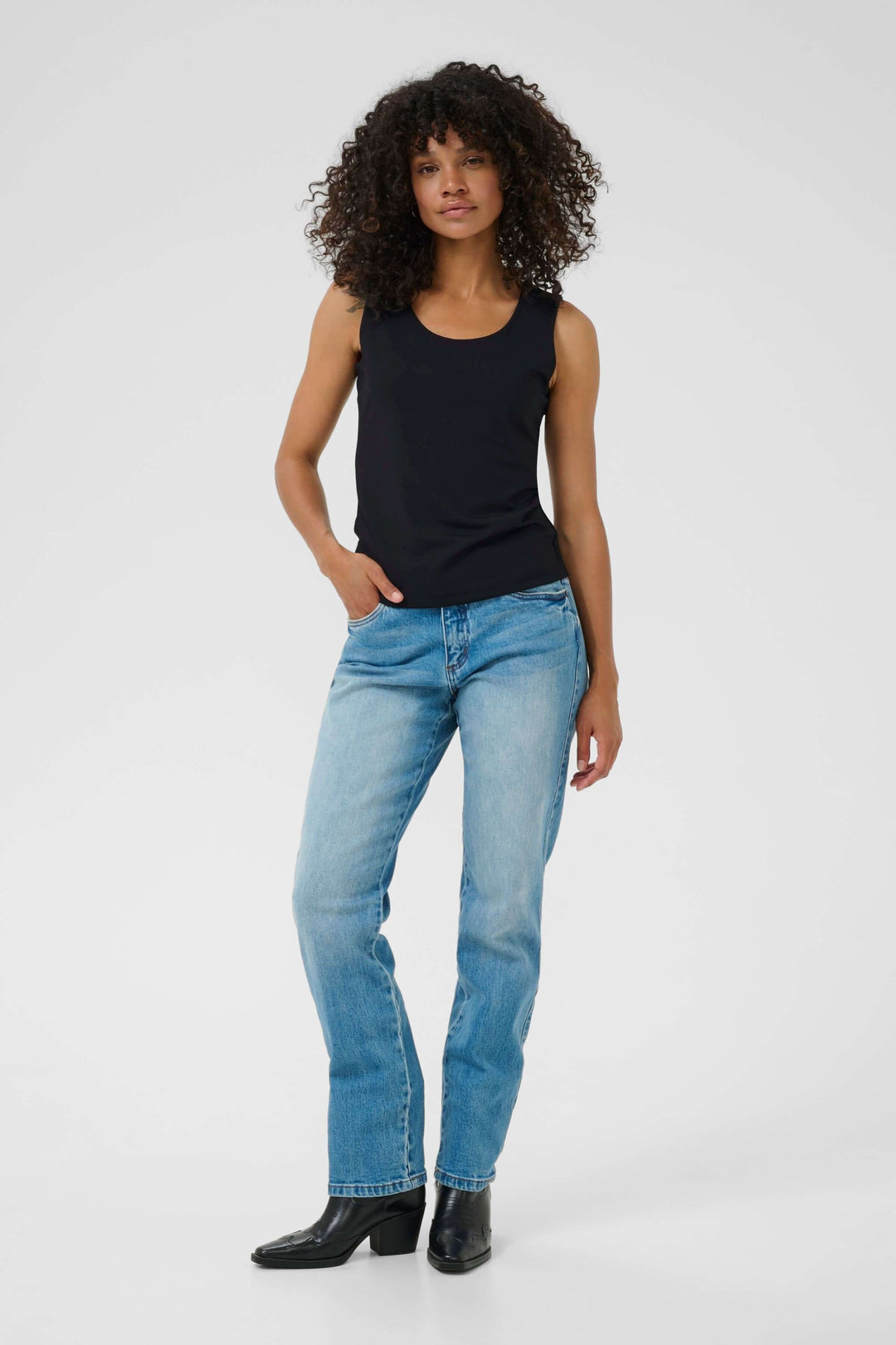 Chandail Arina manches courtes à encolure chaîne décorative porté par mannequin en jean et bottines noires, look moderne.