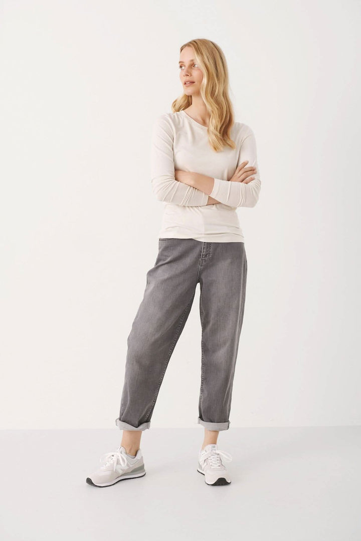Femme portant le chandail Emaja, un haut ajusté avec manches longues, associé à un pantalon décontracté.