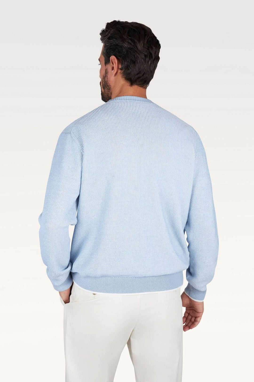 Homme portant un Chandail Piuma en coton ultraléger bleu clair avec finition côtelée, élégance et confort pour la mi-saison.