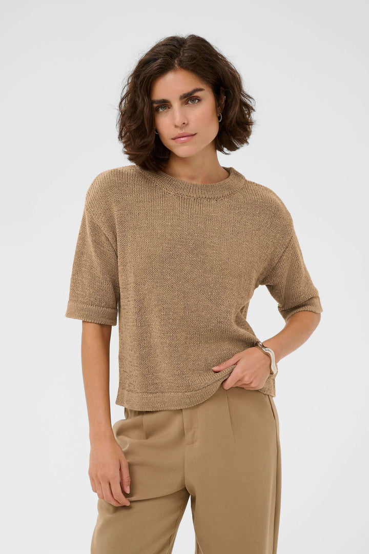 Femme portant le Chandail Sevita en maille légère avec manches courtes, coupe décontractée pour un look moderne et épuré.
