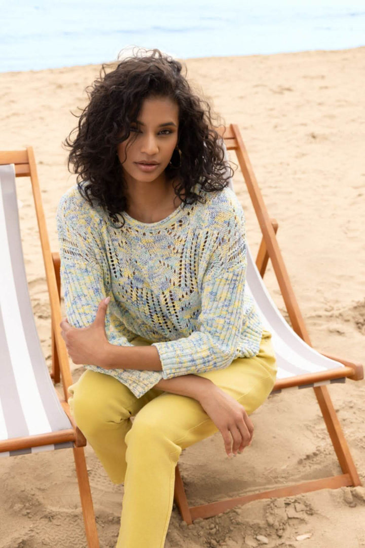 Femme portant un chandail ajouré à motif texturé sur la plage, en vacances d&