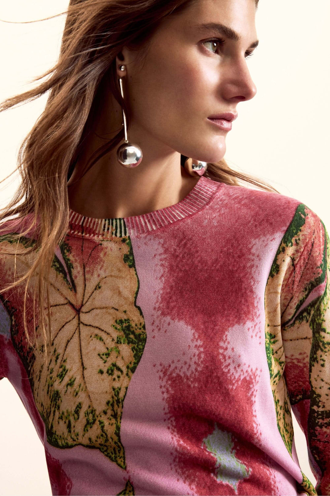 Chandail avec motif graphique végétal, coupe ajustée, manches longues, porté par modèle féminin en profil.