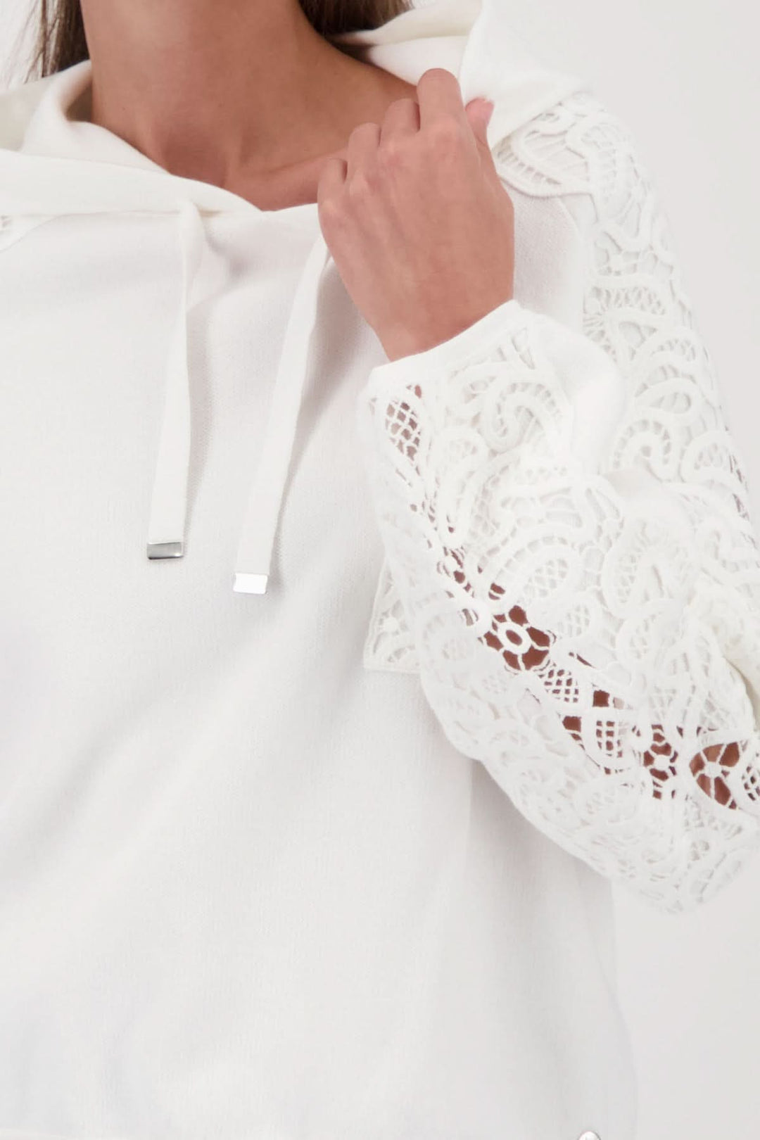 Chandail à capuchon avec broderies décoratives et manche détaillée en dentelle blanche, capuche avec cordons ajustables.
