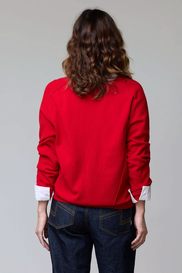 Dos d'une personne portant un chandail col en V classique rouge, coupe droite, avec des finitions côtelées, décontracté et élégant.